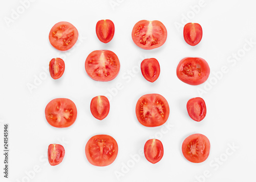 Cut tomatoes on white background, flat lay