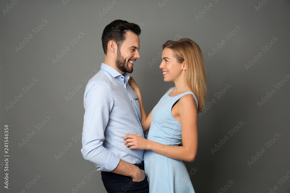 Stylish young couple on grey background Stylish young couple on grey background