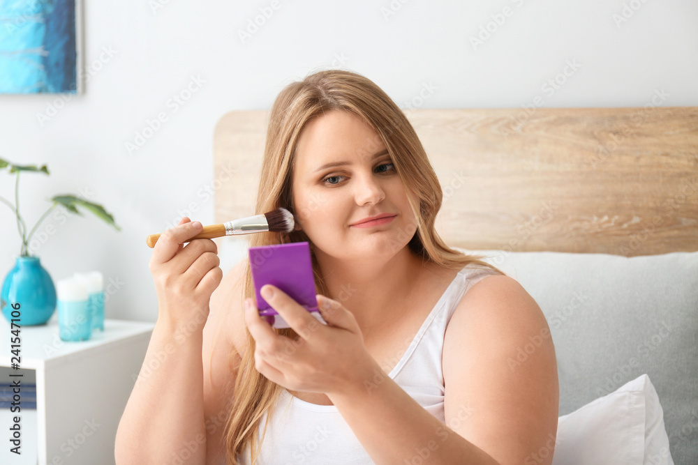 Beautiful plus size girl applying makeup at home. Concept of body positivity Beautiful plus size girl applying makeup at home. Concept of body positivity