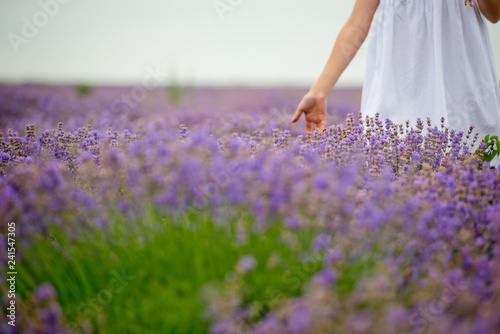 Young girl in white dress, posing in a lavender field. Close-up.