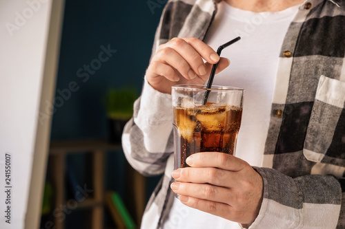 Woman drinking tasty soda at home