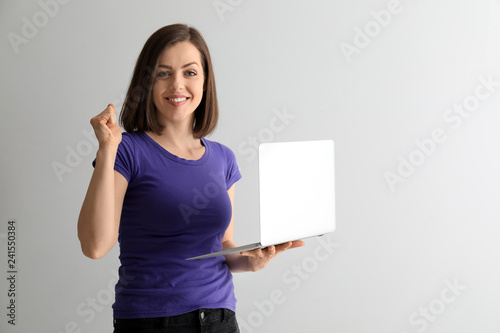 Happy young woman with lapt...