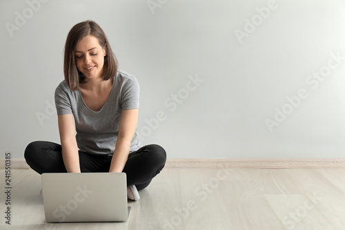 Young woman with laptop sit...