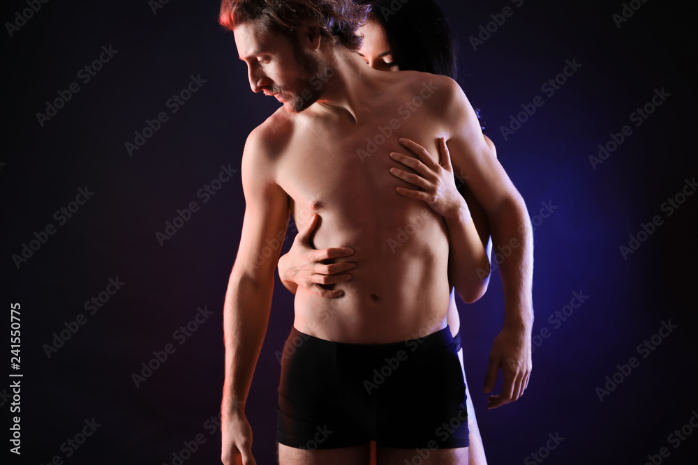 Fototapeta premium Passionate young couple on dark background