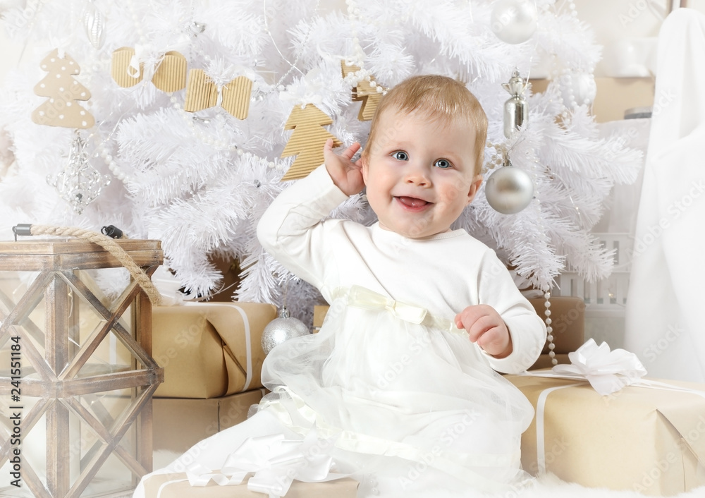 Cute little girl sitting under a Christmas tree