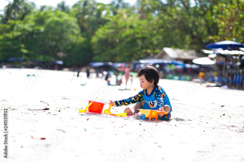 Little boy baby playing with sand on sea shore, Happy time on summer beach