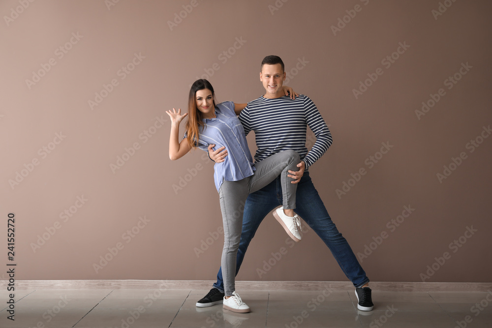 Obraz premium Couple of young dancers near color wall