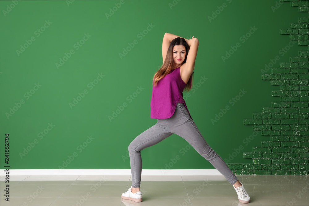 Young woman dancing near color wall Young woman dancing near color wall