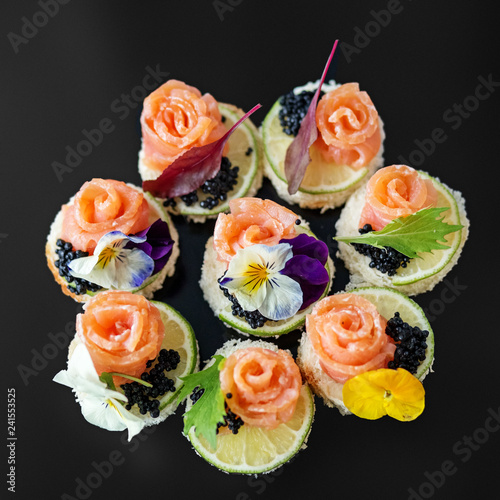 Delicious appetizer with salmon and edible flowers. Concept for food  restaurant  menu  catering.