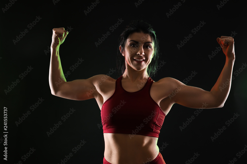 Sporty muscular woman on dark background Sporty muscular woman on dark background