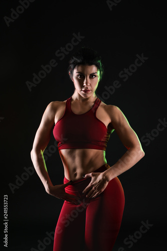 Sporty muscular woman on dark background