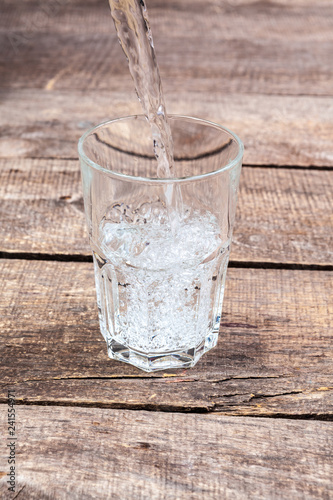 Glasses of water on a wooden table.