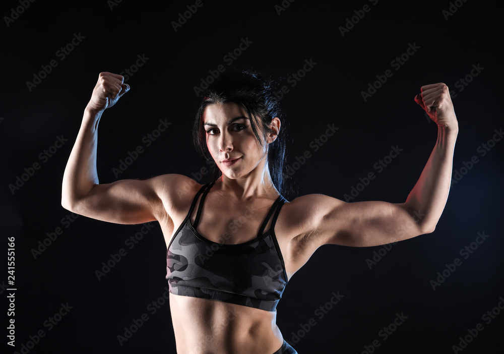 Sporty muscular woman on dark background Sporty muscular woman on dark background