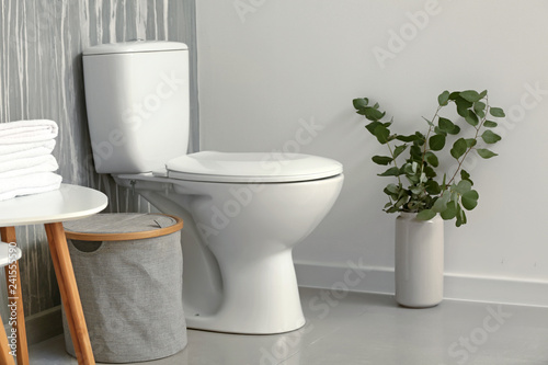 Modern interior of restroom with ceramic toilet bowl photo