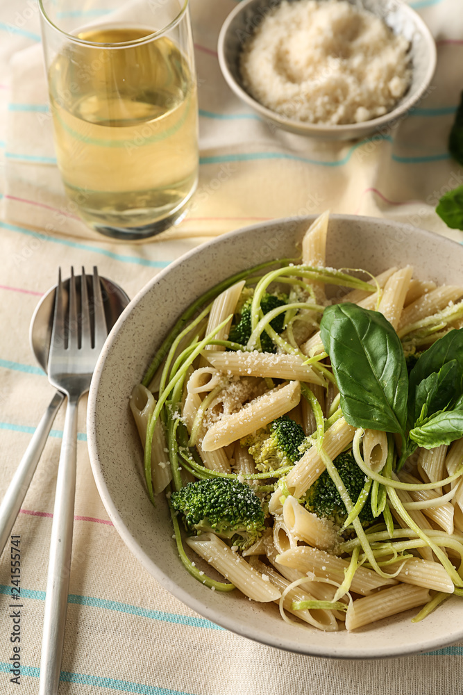 Plate with tasty pasta and green vegetables on table