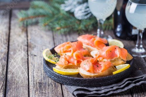 Plate of fresh salmon fillet with bread on wooden background