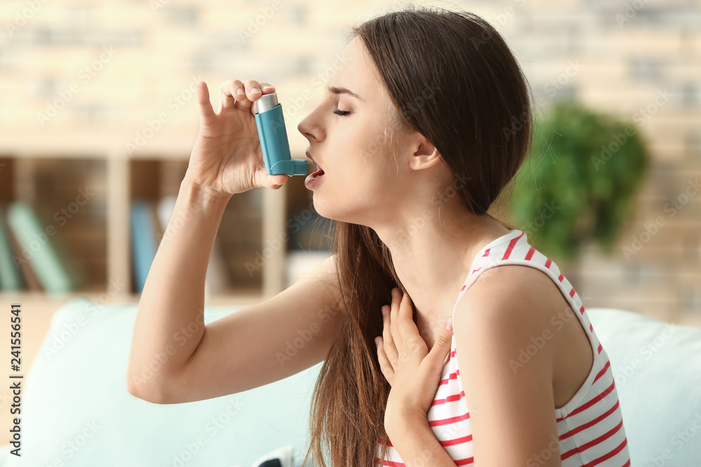 Young woman with inhaler having asthma attack at home Young woman with inhaler having asthma attack at home
