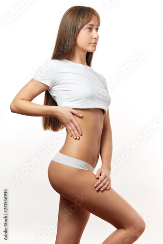 Beautiful caucasian woman with natural long hair, wearing white top and undies isolated on white.Young woman in white panties