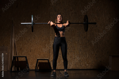Woman performs deadlift with weight in the gym