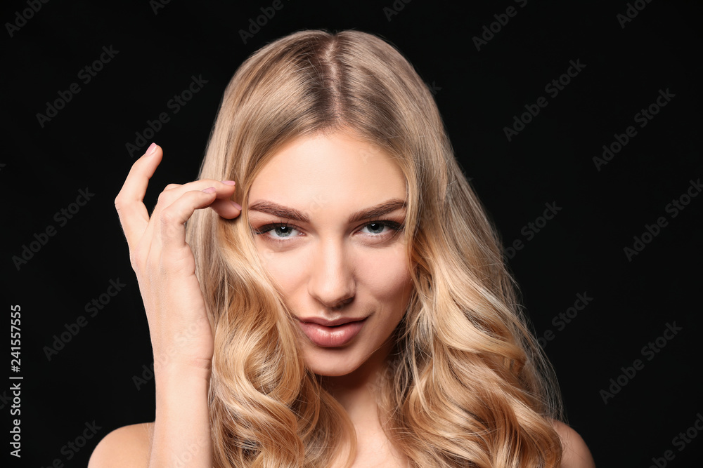 Young woman with beautiful curly hair on dark background Young woman with beautiful curly hair on dark background