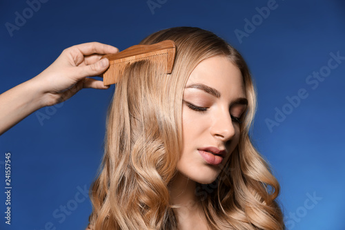 Female hand combing hair of...