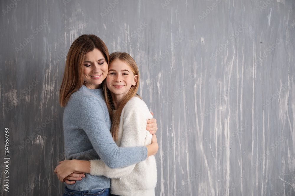 Portrait of happy mother and daughter on grey background Portrait of happy mother and daughter on grey background