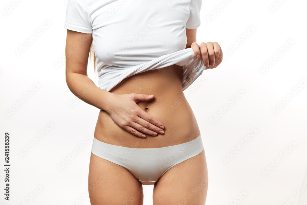 Healthy woman body, waistline. Female Hand on belly. Slim female torso,  small waist, belly, close up. Female mid-section shot over white  background. Sport,Fitness, weightloss concept Stock Photo