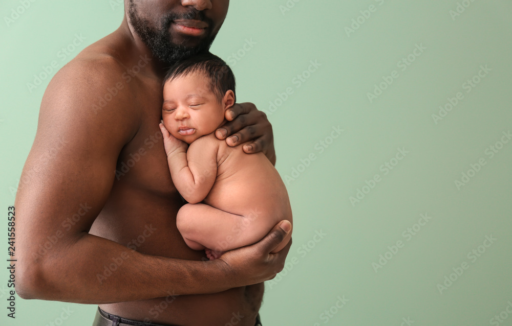 Happy African-American father with little baby on color background - obrazy, fototapety, plakaty 