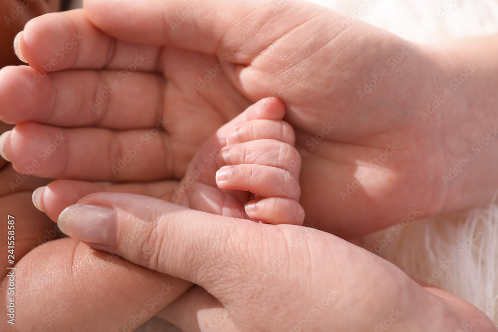 Hands of mother and cute little baby, closeup Hands of mother and cute little baby, closeup
