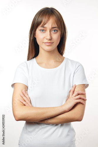 Studio shot of brunette fit woman with slender legs, wears casual white t shirt and pants, demonstrates healthy lifestyle, looks confidently at camera, has healthy cared skin and hair © alfa27