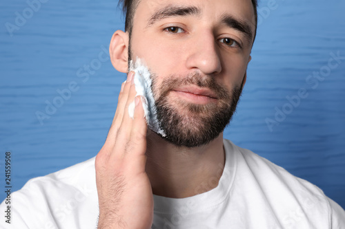 Handsome man applying shavi...
