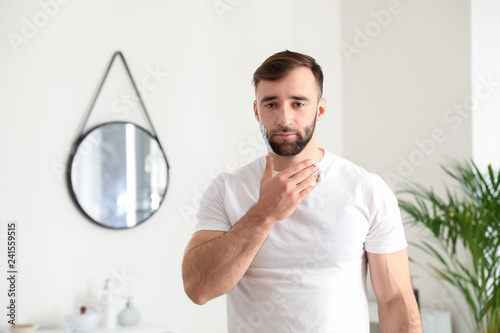 Handsome man applying shavi...