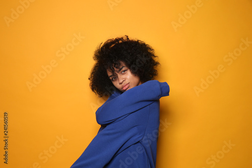 Portrait of young African-American woman on color background © Pixel-Shot