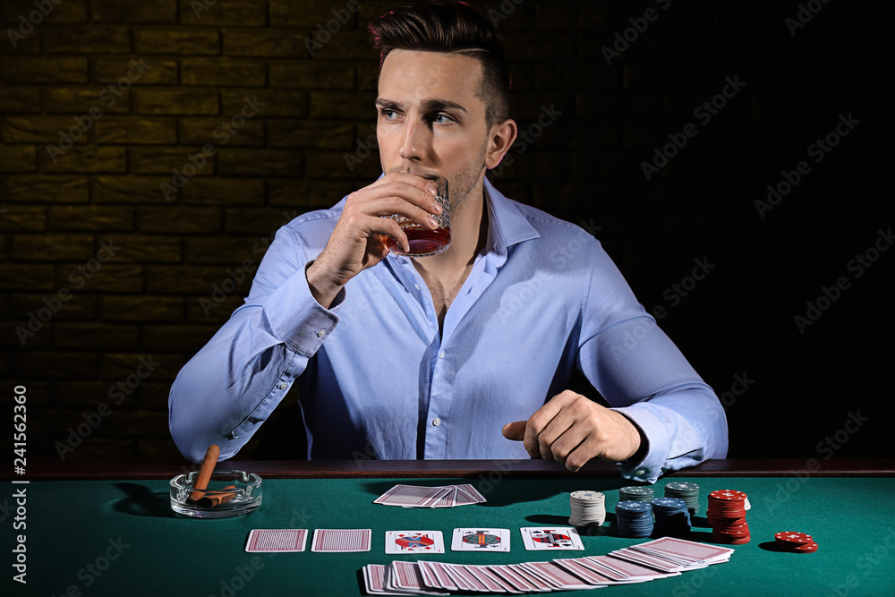 Handsome male player at table in casino Handsome male player at table in casino