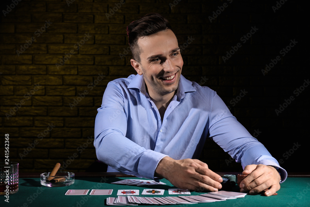 Handsome male player at table in casino Handsome male player at table in casino