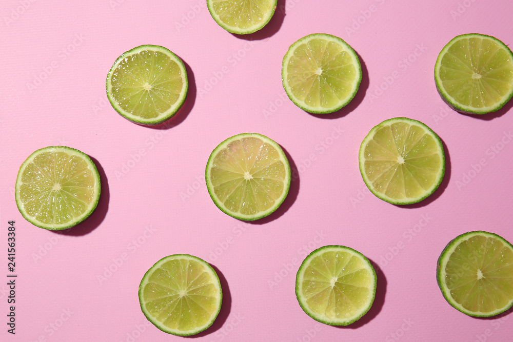 Many slices of lime on color background