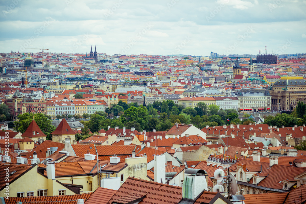 Elevated view over the rooftops and cityscape of Prague on a dull day. Shows the bright colourful buildings, the churches, architecture, statues and monuments.