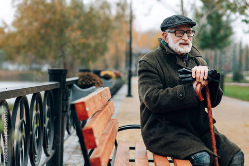 Kind grey-haired male person having rest during walk