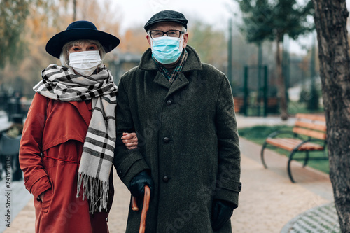 Mature couple wearing sterile face masks while walking