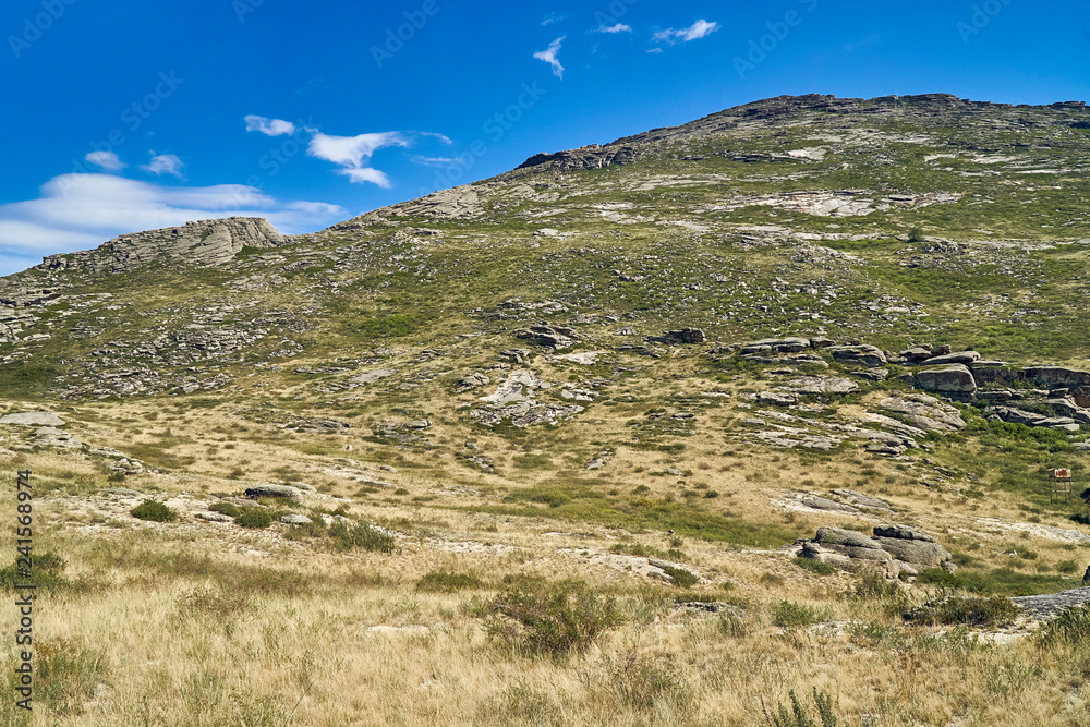 Beautiful panoramic summer steppe landscape of stone mountains 