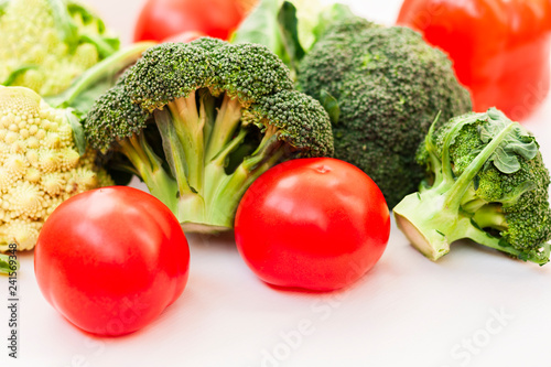 Ripe vegetables tomatoes romanesco broccoli on white wooden background with copy space for your text