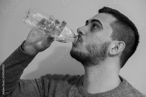 Portrait of a young boy drinking water.