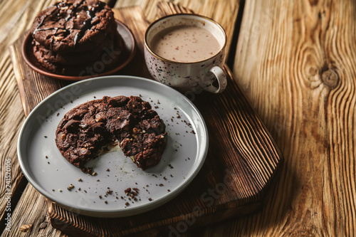 Tasty chocolate cookies with cacao drink on wooden table