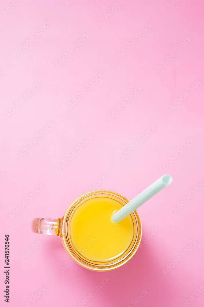 Colorful composition with mason jar glass full of fresh orange juice with straw, fruit, isolated on pink background. Close up, copy space, top view. Colorful composition with mason jar glass full of fresh orange juice with straw, fruit, isolated on pink background. Close up, copy space, top view.