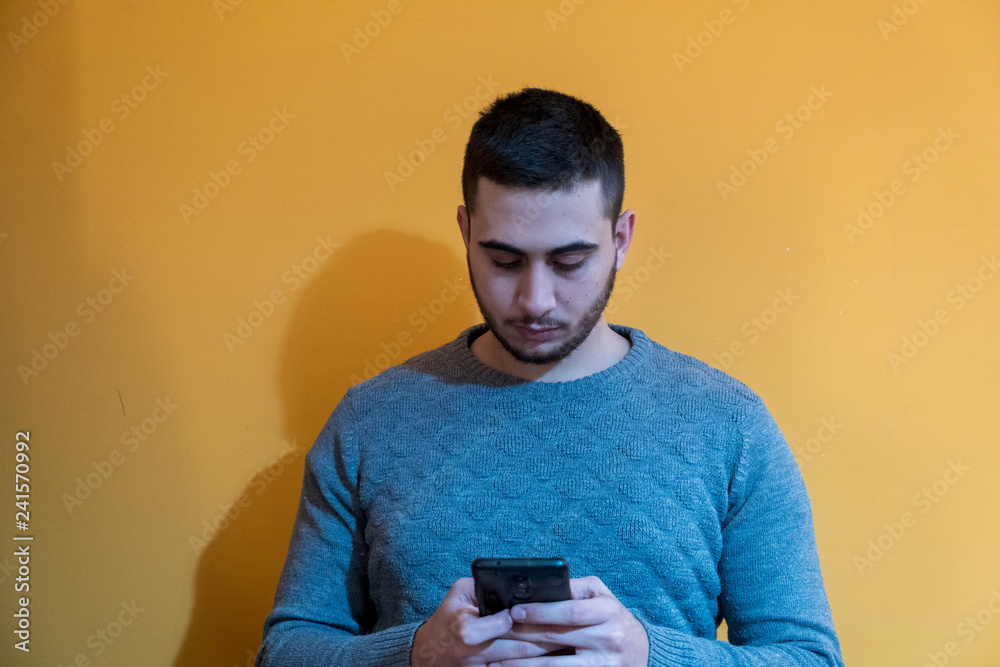 Portrait of a pensive young boy while using the phone. Portrait of a pensive young boy while using the phone.