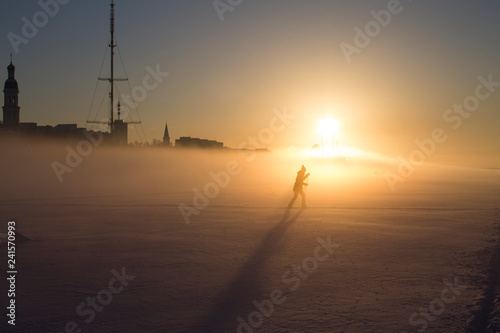 силуэт лыжника на золотом фоне заходящего солнца