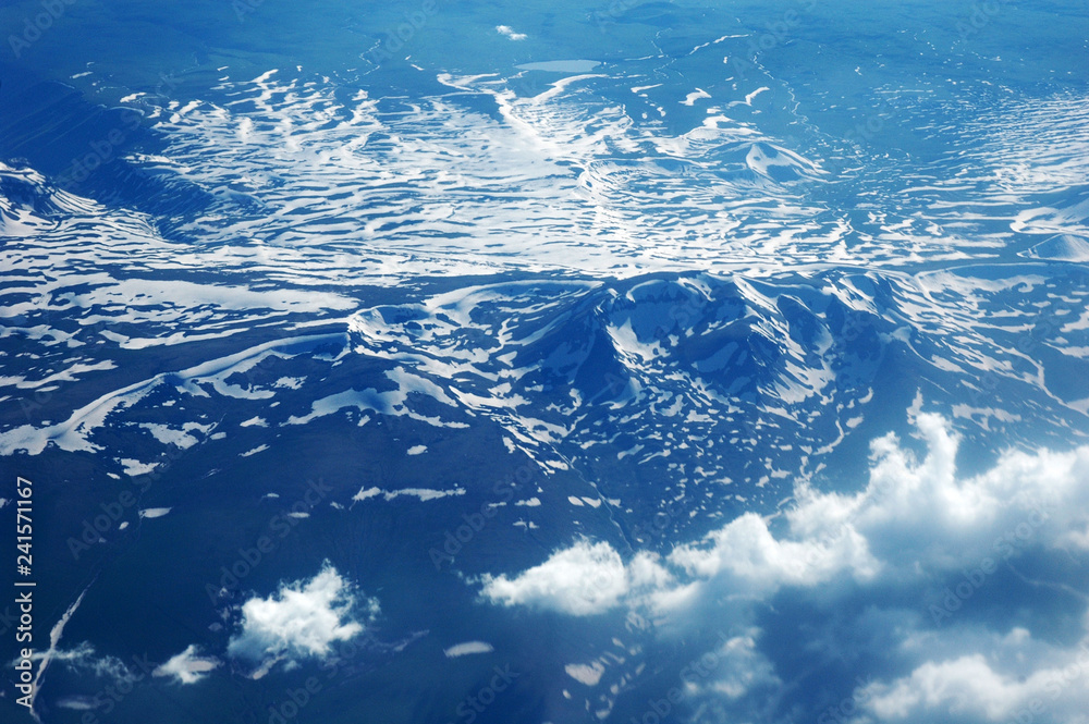 Mountains, snow and clouds from the height of the plane