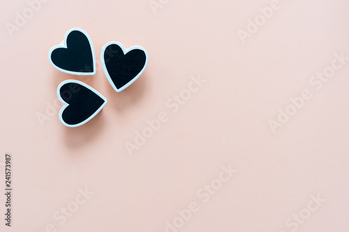 Cream colored background, with three black hearts on one end. Love concept, for Valentine's day, mother's day, father's day, Christmas, holidays.