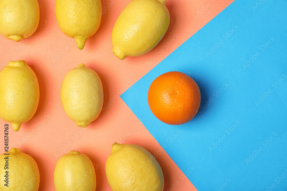 Orange in front of lemons on color background, top view. Be different - obrazy, fototapety, plakaty 