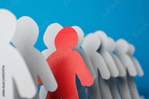 Paper people and different one on color background